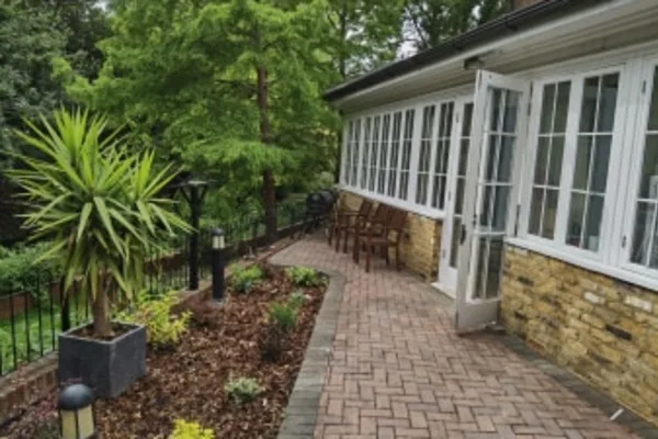 Garden pathway and conservatory at Bridge House Care Centre, Wallington